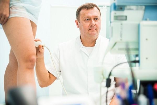 Доктор Семенов А.Ю. проводит ультразвуковое сканирование вен